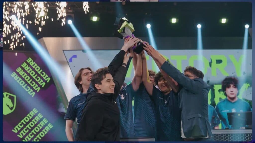Članovi tima u dresovima Team Liquida zajedno podižu trofej na pozornici.