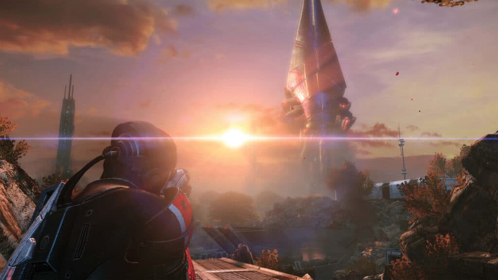 Oklopljeni lik promatra golemi stroj iznad stjenovitog krajolika u Mass Effect Legendary Editionu.